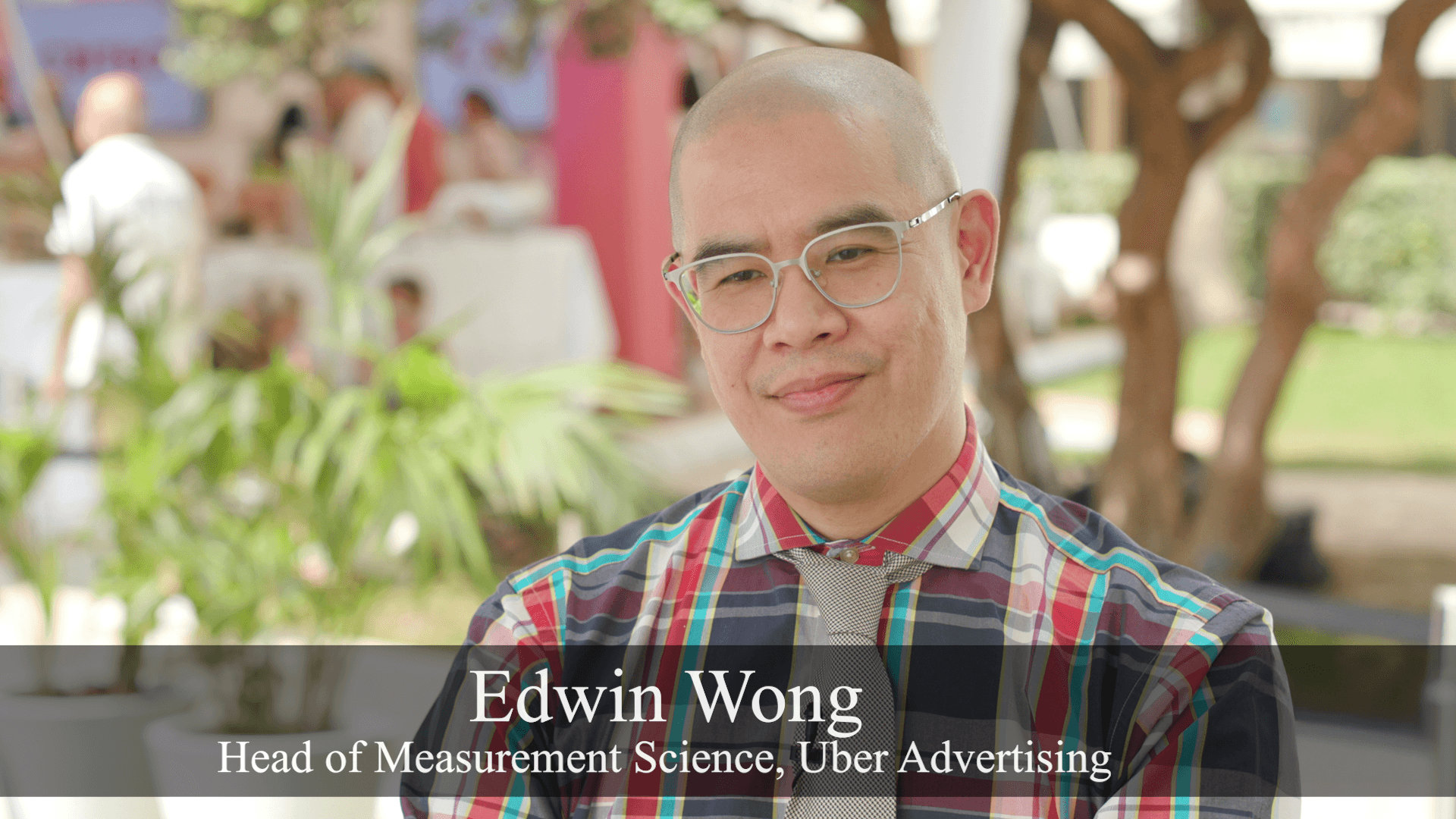 Edwin Wong in front of outdoor foliage.