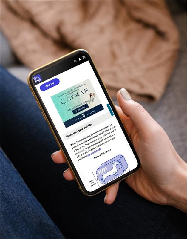 Hand holding a cellphone with a Cayman Island ad on the screen.