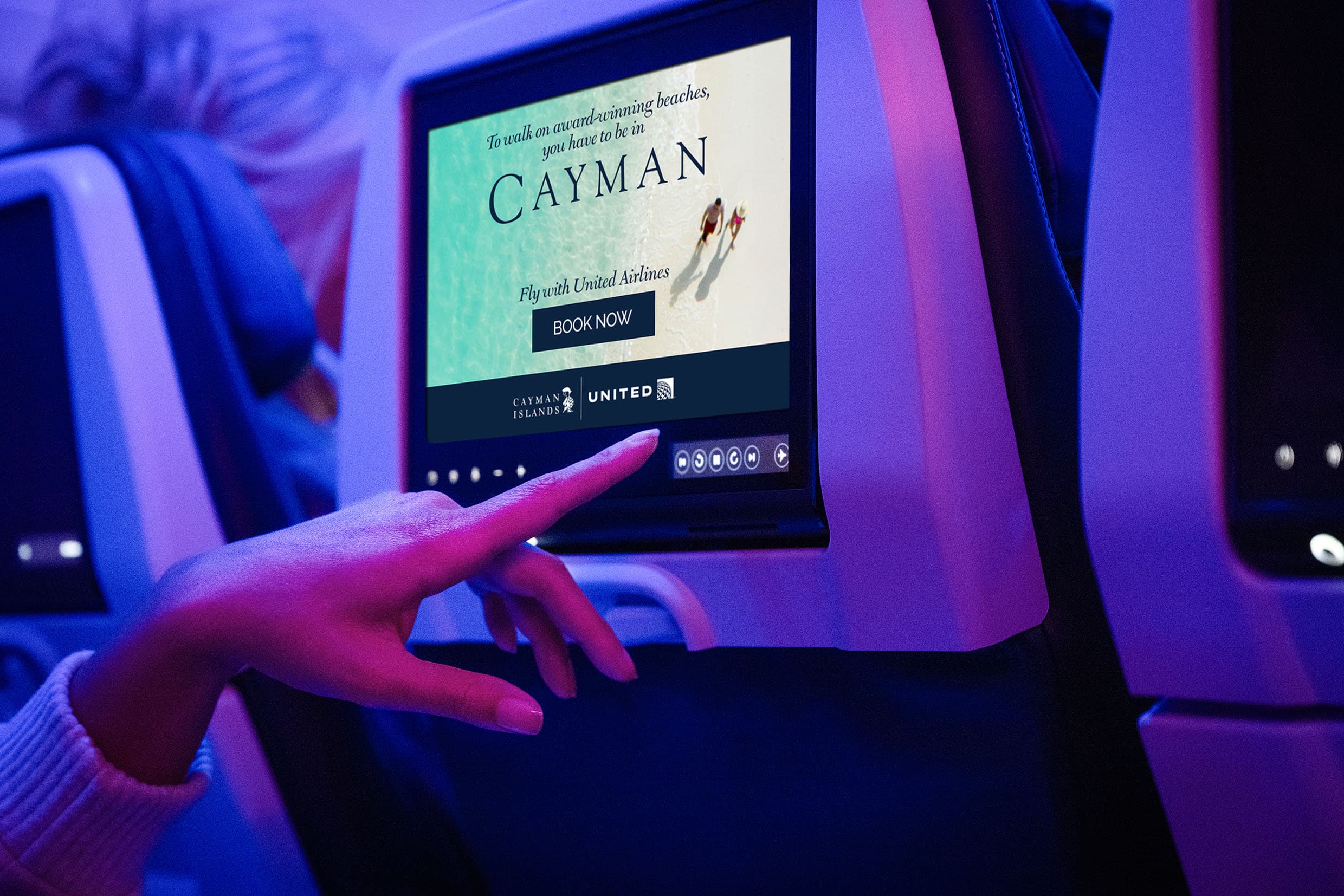 Man sitting on a plane, watching the seat back monitor