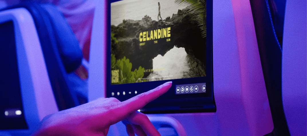 A person on a plane touching a seatback display.